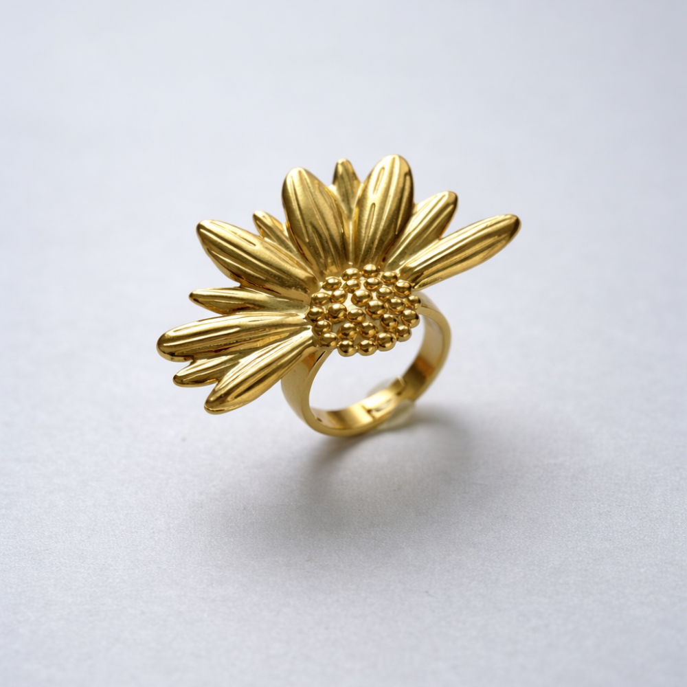 Gold sunflower-shaped ring on a light gray background