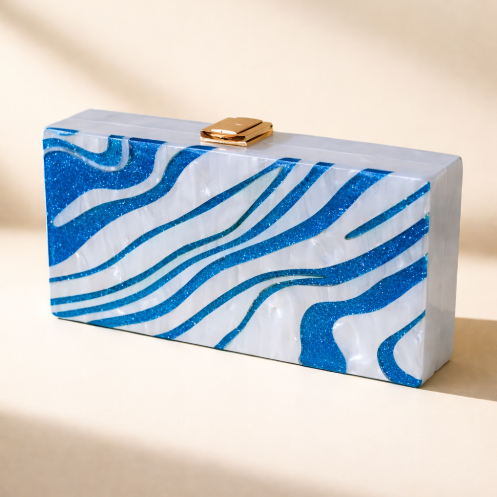 Blue and white marbled clutch bag with a gold clasp on a beige background