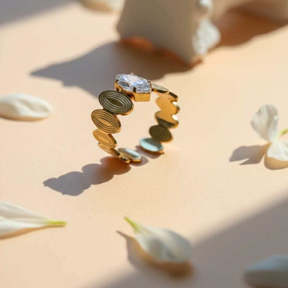 Gold ring with a diamond on a beige surface with white flowers
