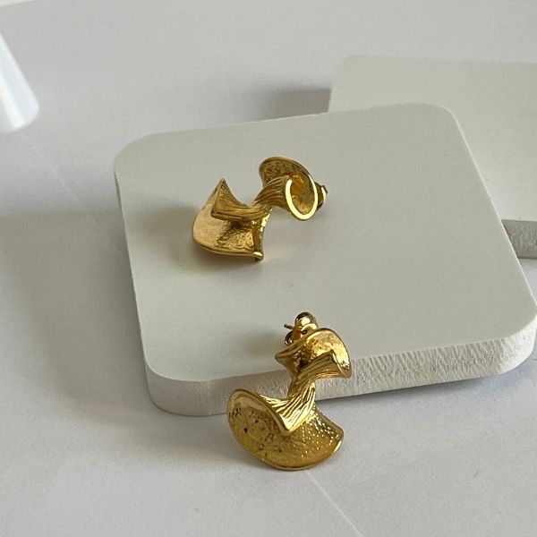A pair of gold-plated, twisted retro glam stud earrings on a white background.