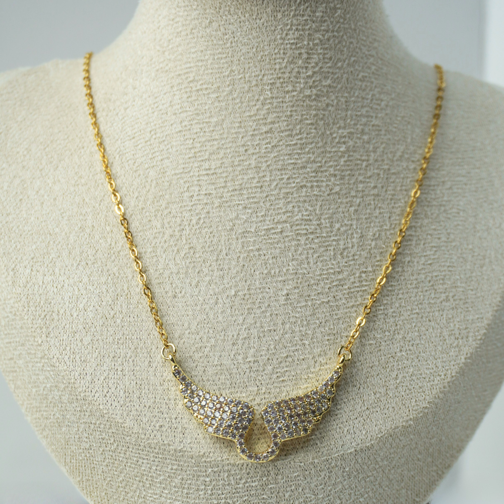Gold necklace with a decorative clasp on a mannequin bust.