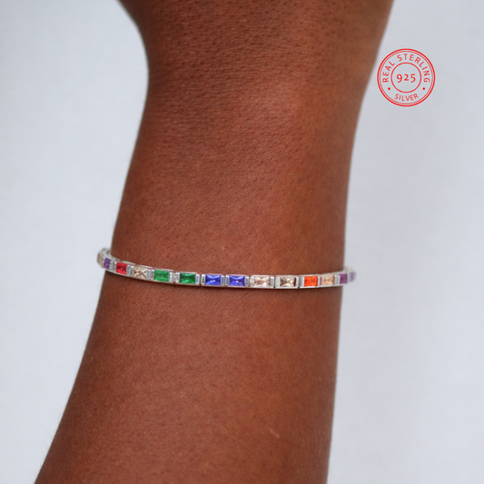Multicolored gemstone bracelet on a wrist with 'Real Sterling Silver' stamp.