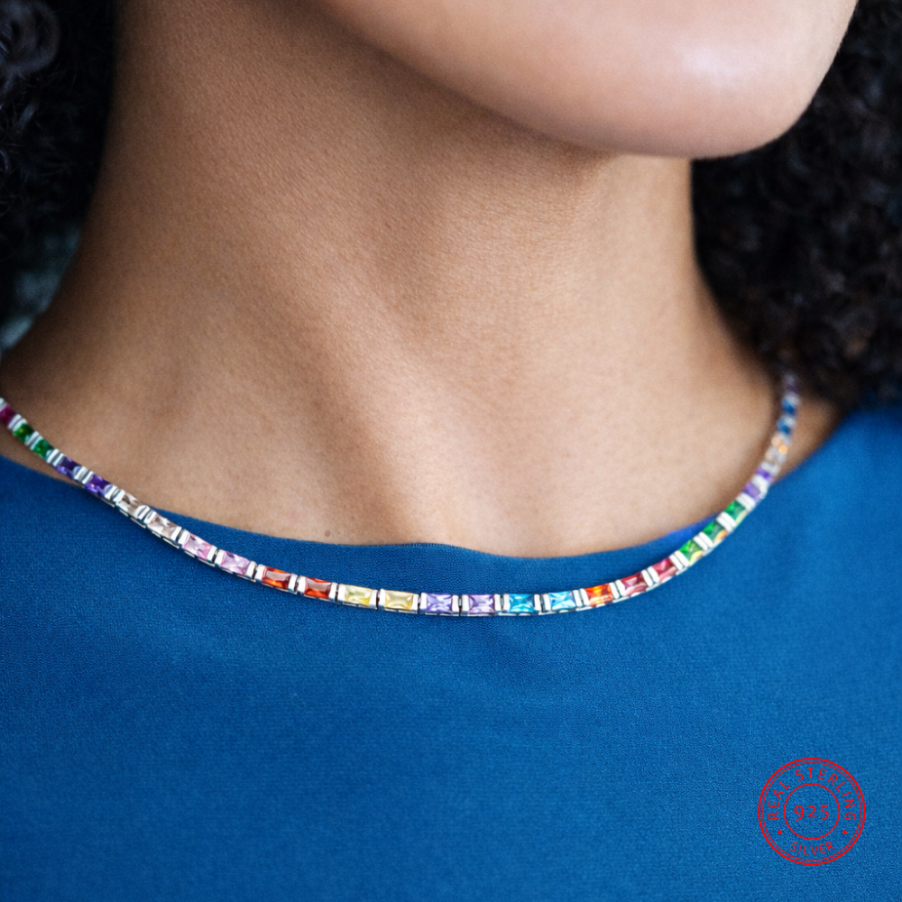 Close-up of a colorful beaded necklace on a person wearing a blue shirt.