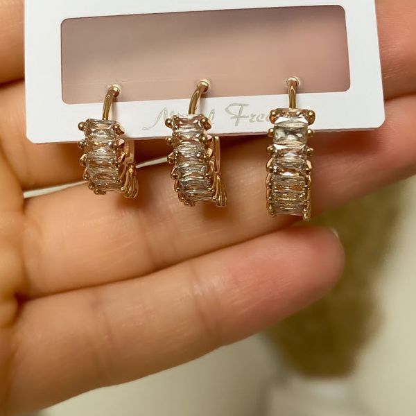 A set of three gold-plated zircon hoop earrings with rhinestone embellishments, presented on a branded card.