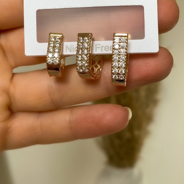 A set of gold-plated, rectangle-shaped hoop earrings adorned with rhinestones, displayed on a card.