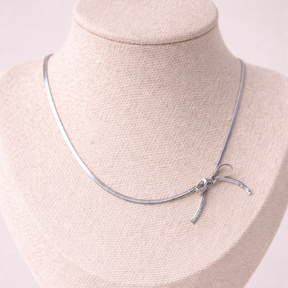 Silver necklace on a mannequin bust with a plain background