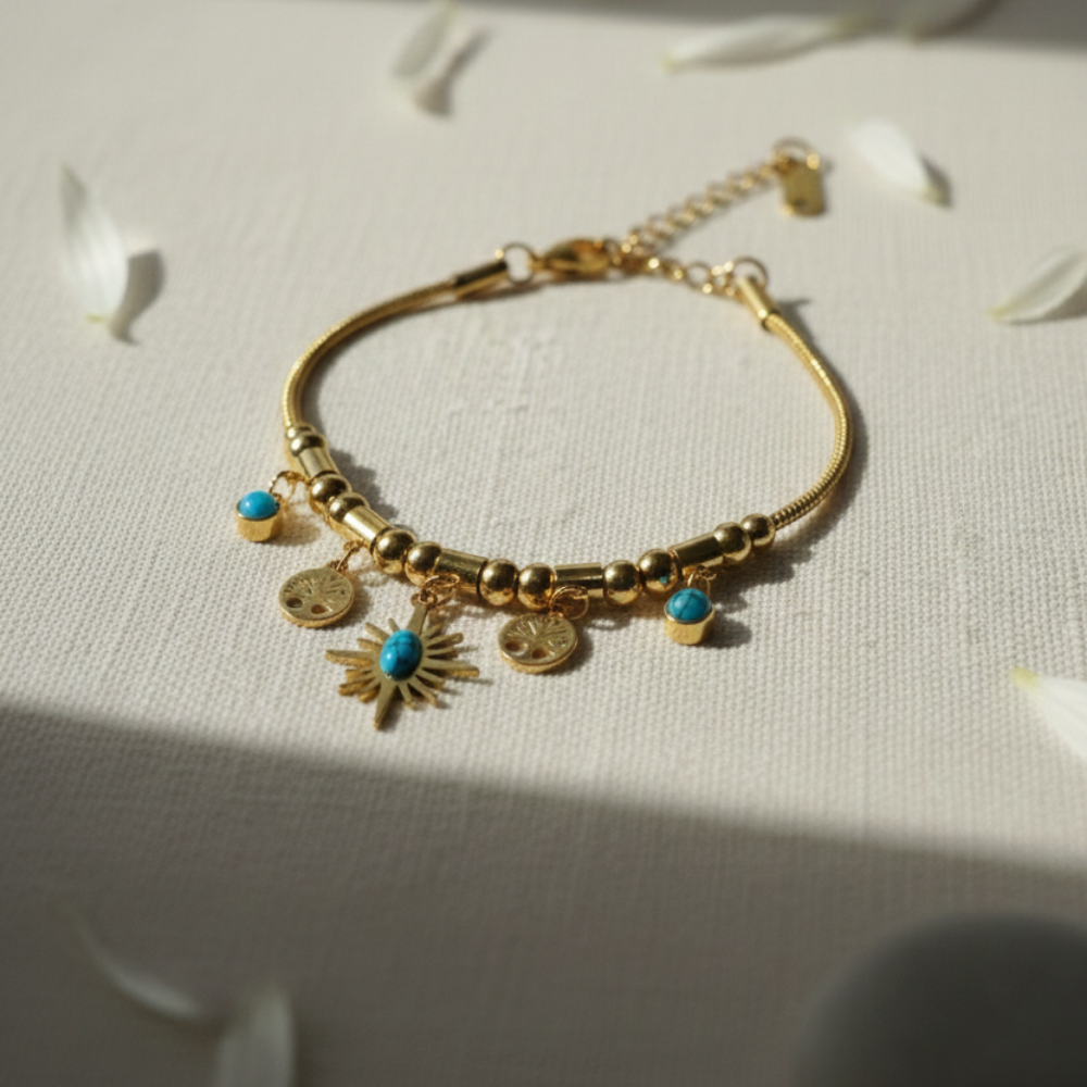 Gold bracelet with charms on a light background
