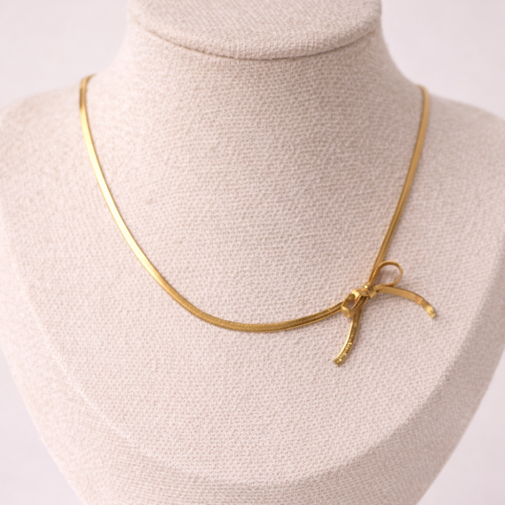 Gold necklace on a mannequin bust against a white background