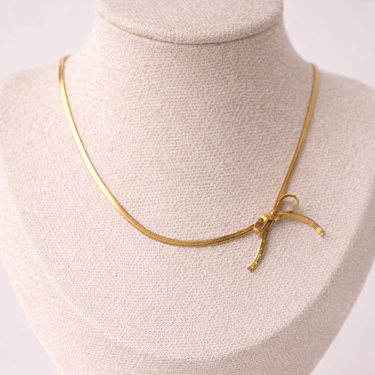 Gold necklace on a mannequin bust against a white background