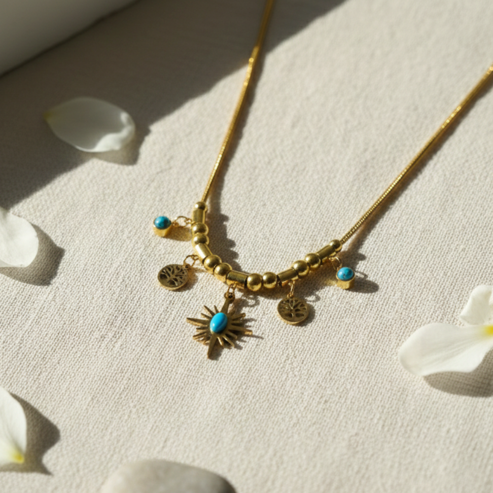 Gold necklace with charms on a light fabric background