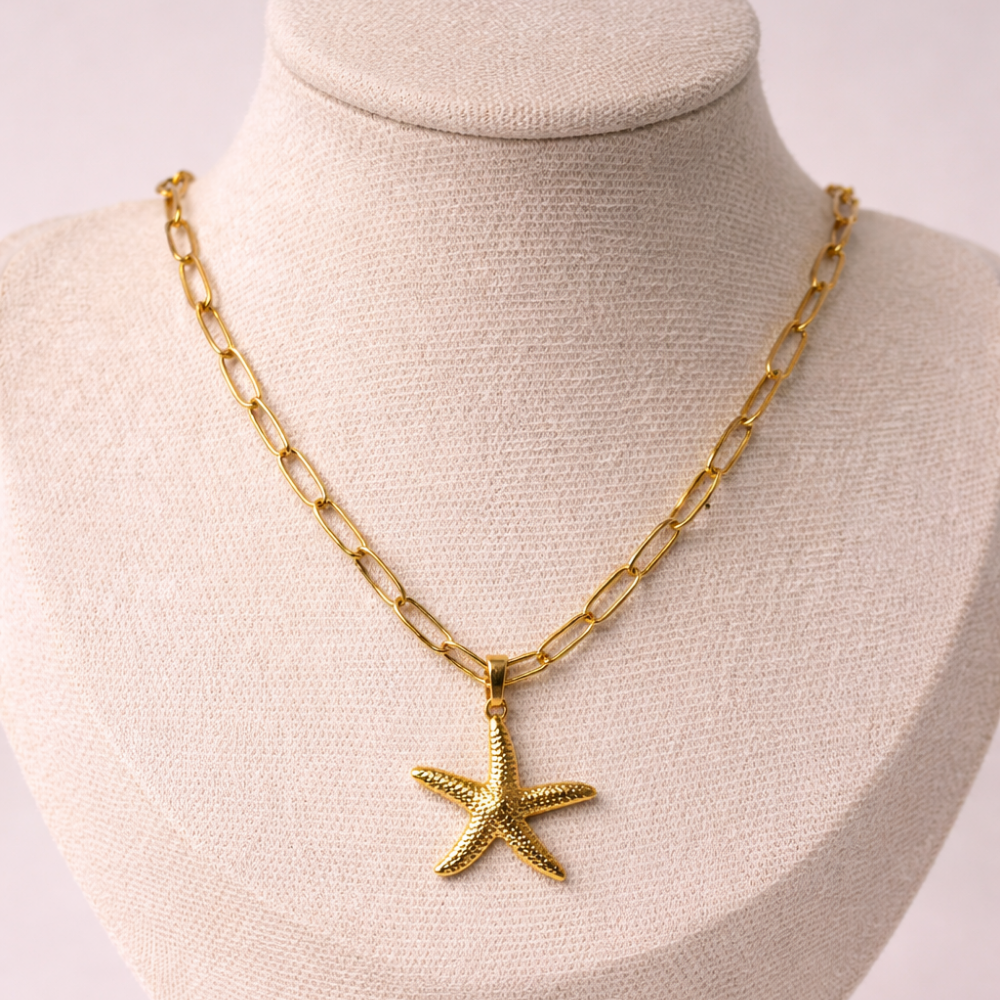 Gold chain necklace with a starfish pendant on a mannequin bust.