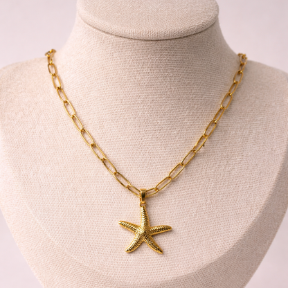 Gold chain necklace with a starfish pendant on a mannequin bust.