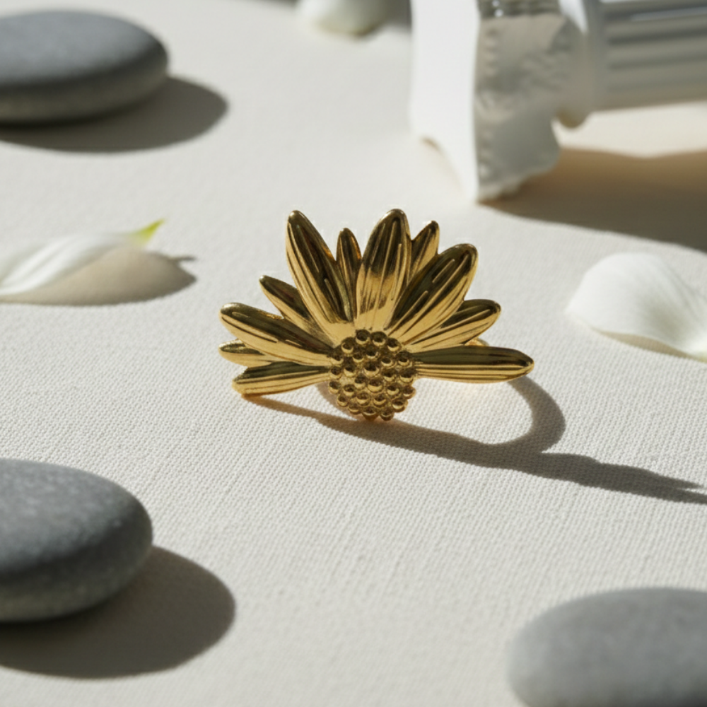 Gold flower-shaped object on a textured surface with stones