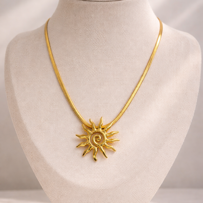 Gold necklace with a sun pendant on a mannequin bust.