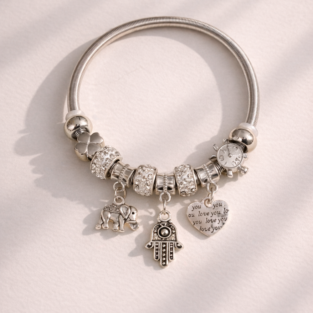 Silver bracelet with various charms on a light background