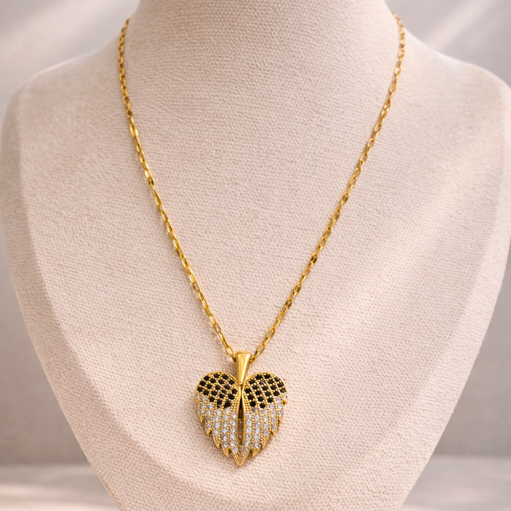 Gold necklace with a heart-shaped pendant on a mannequin bust.