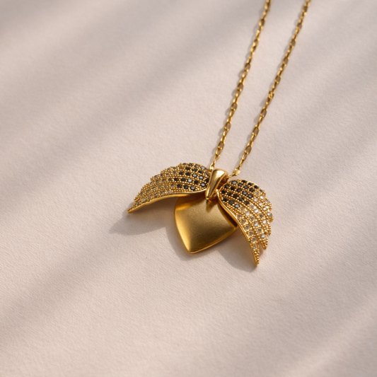 Gold necklace with a leaf-shaped pendant on a beige background