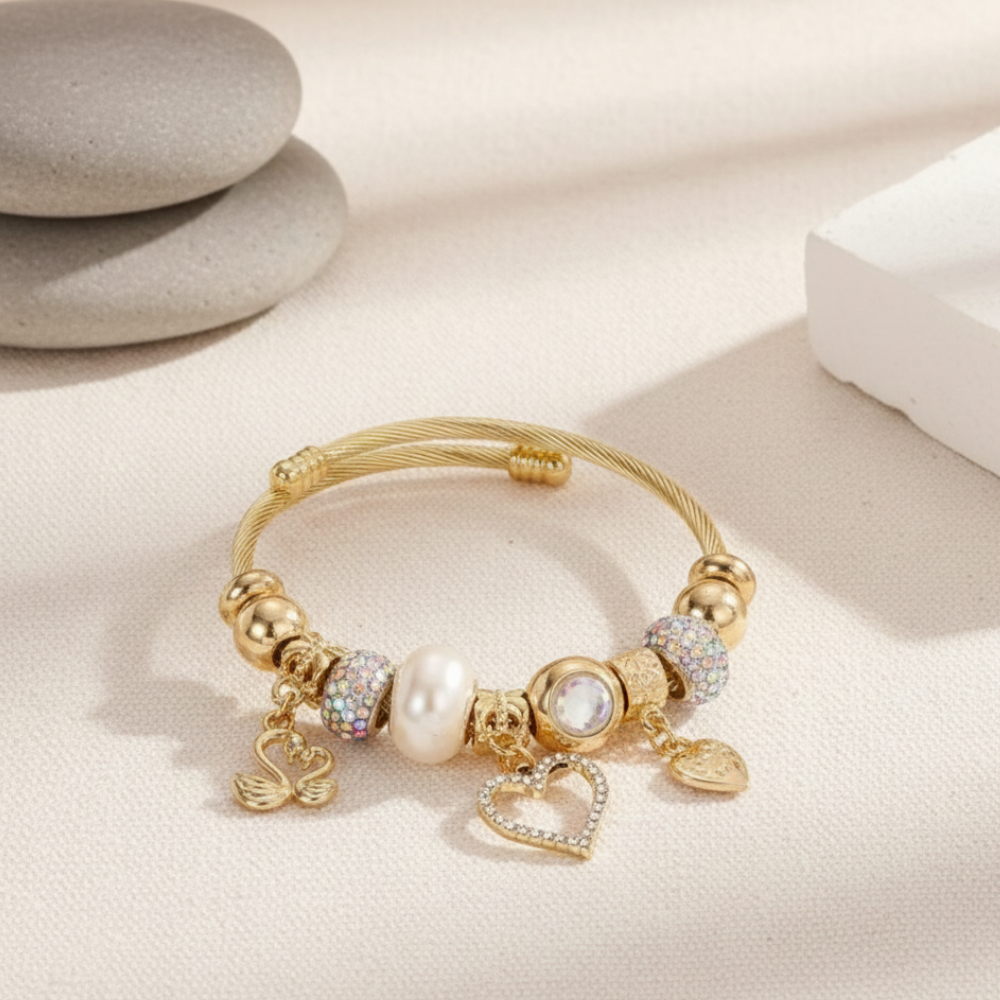 Gold bracelet with charms on a light beige surface
