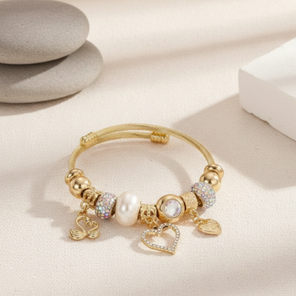 Gold bracelet with charms on a light beige surface