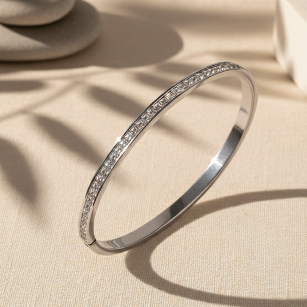 Silver bracelet with small stones on a beige fabric background