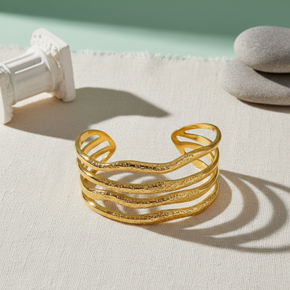 Gold bracelet on a light surface with a minimal background