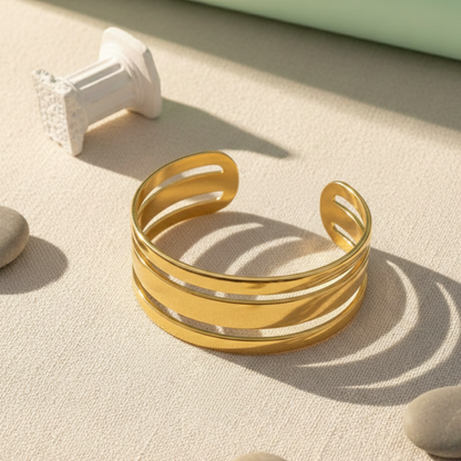 Gold bracelet on a textured surface with soft shadows