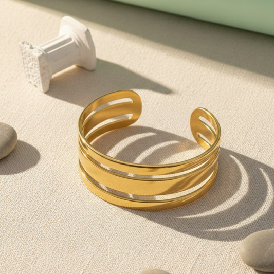 Gold bracelet on a textured surface with soft shadows