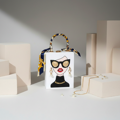 Designer handbag with face design and decorative handle on a neutral background