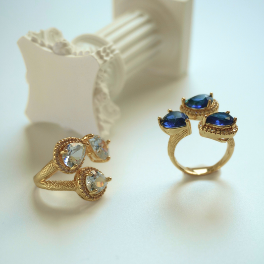 Gold rings with gemstones on a light background