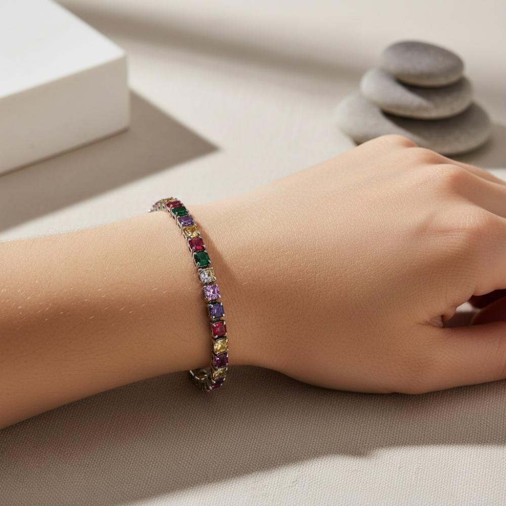 Multicolored gemstone bracelet on a wrist with a neutral background