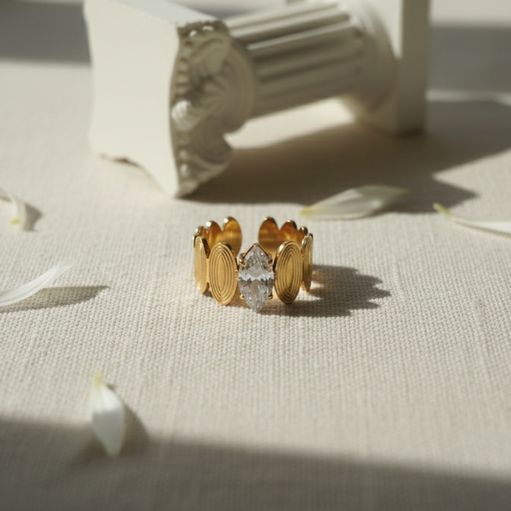 Gold ring with a central diamond on a textured surface