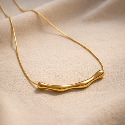 Gold necklace on a beige fabric background