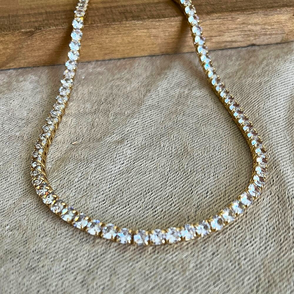 Zirconia tennis necklace with clear stones on a textured surface