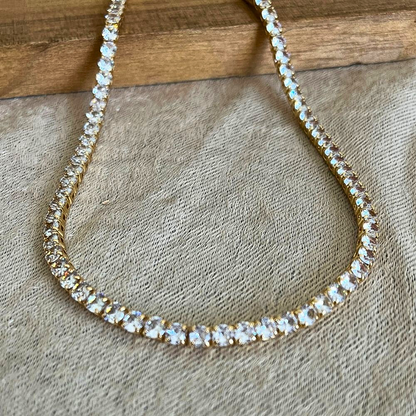 Zirconia tennis necklace with clear stones on a textured surface