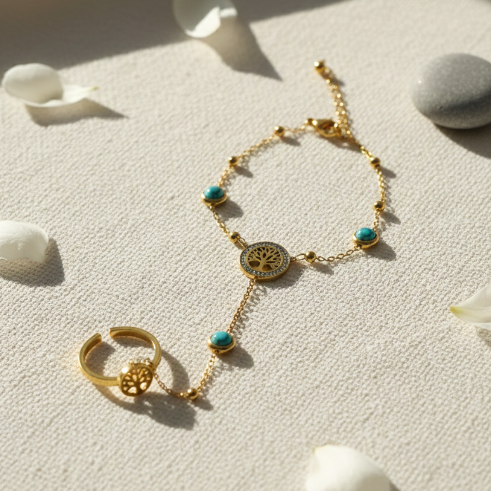 Gold bracelet and ring with turquoise stones on a textured surface with shells.