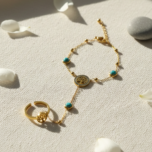 Gold bracelet and ring with turquoise stones on a textured surface with shells.