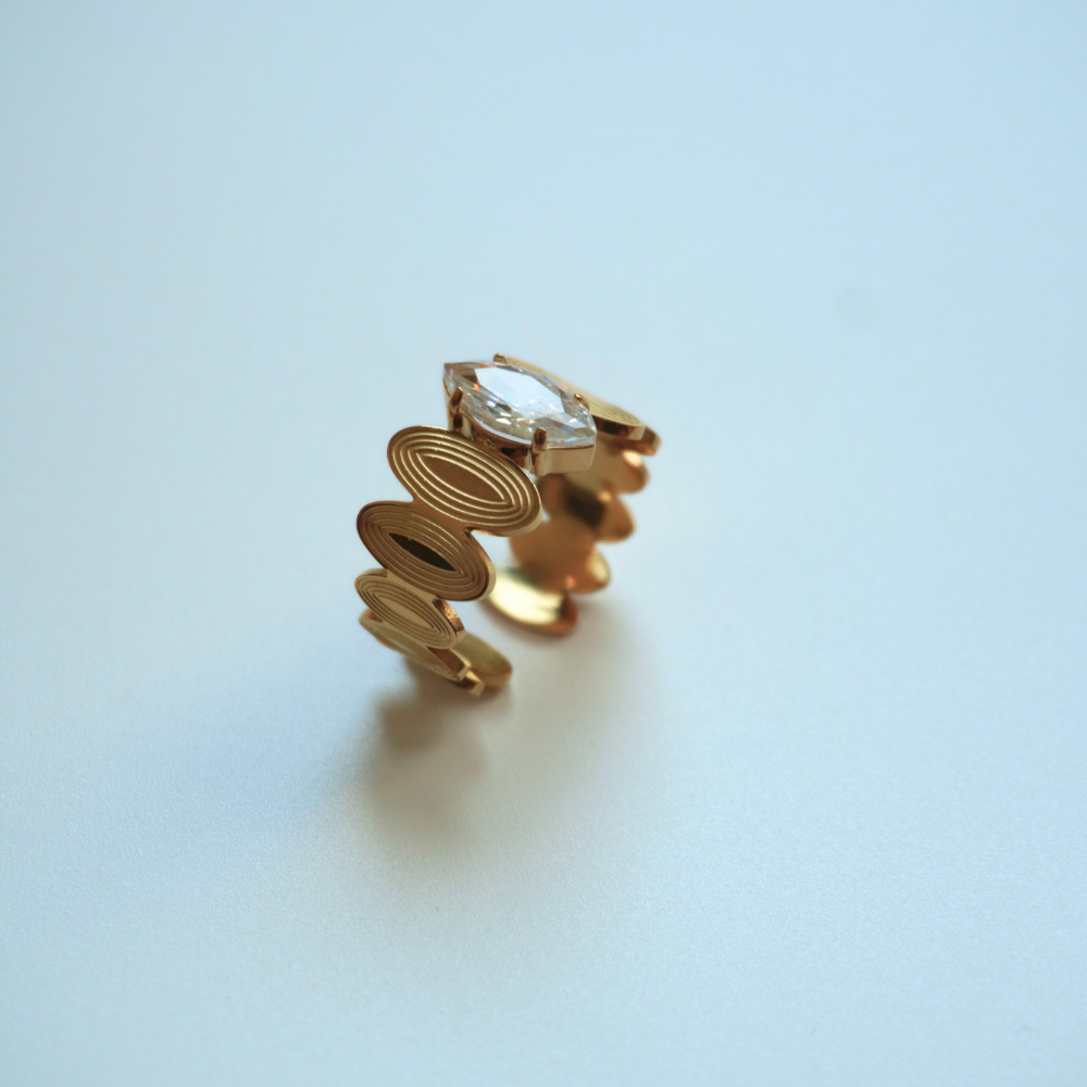 Gold earring on a light blue background
