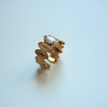 Gold earring on a light blue background