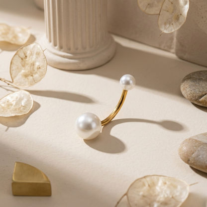 Gold and pearl earring on a neutral background with decorative elements