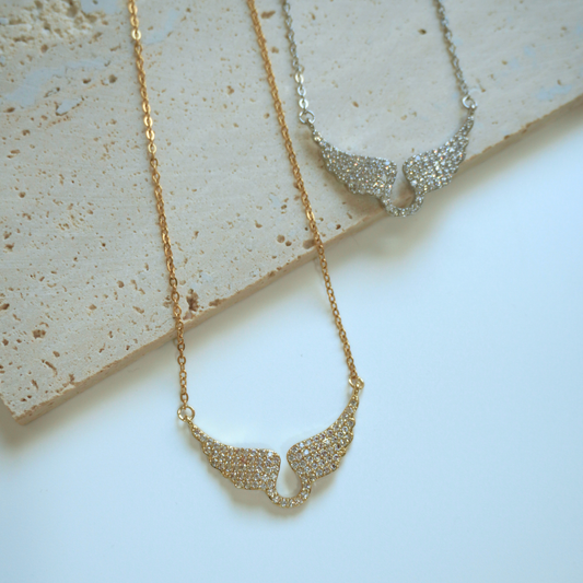 Gold and silver necklaces on a textured surface
