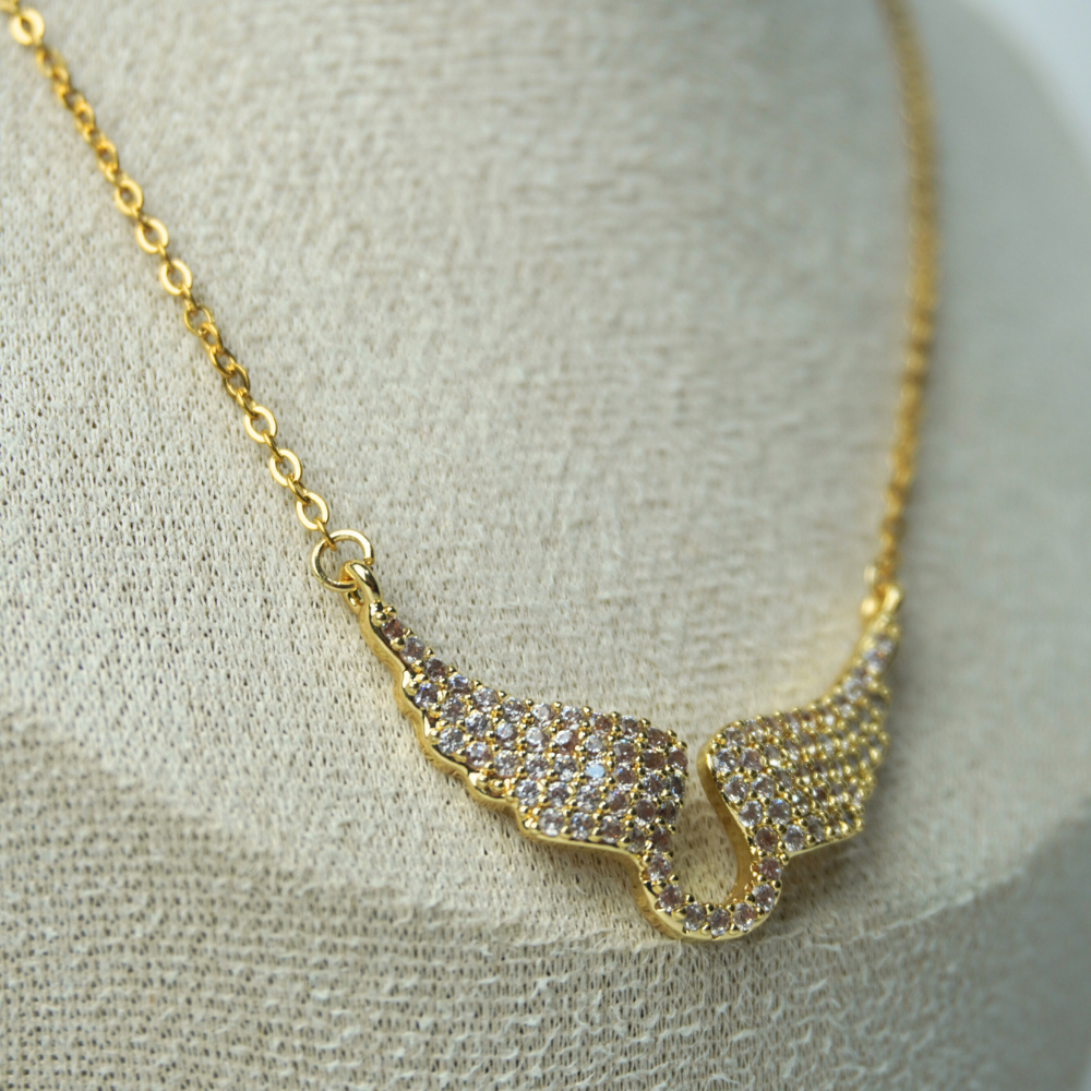 Gold necklace with a unique pendant on a textured surface