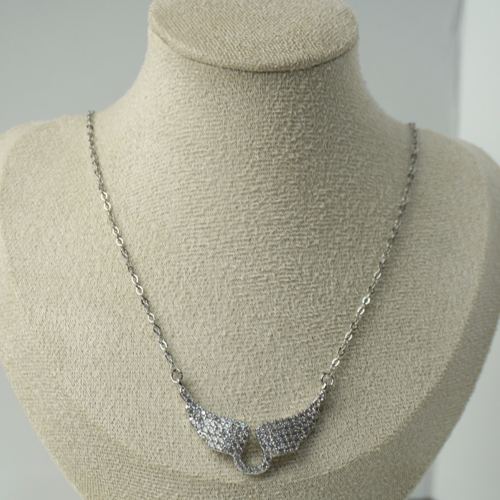 Silver necklace on a mannequin bust against a neutral background