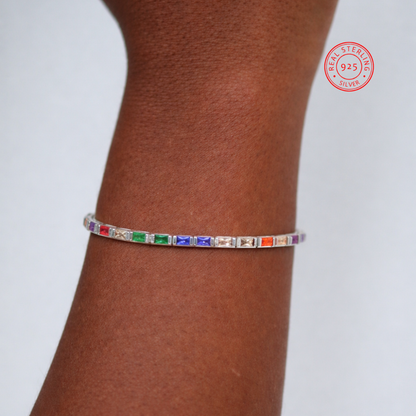 Multicolored gemstone bracelet on a wrist with 'Real Sterling Silver' stamp.