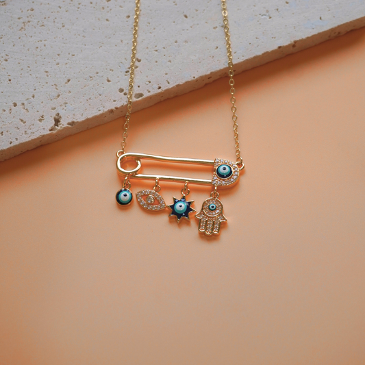 Necklace with charms on a peach and gray background