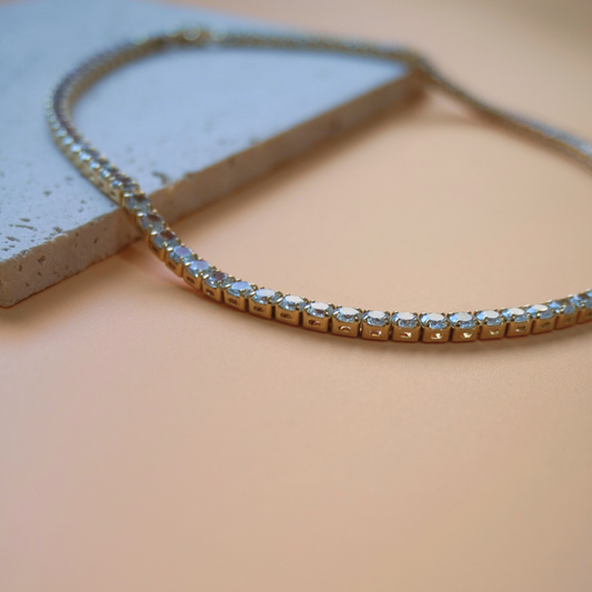 Zirconia tennis necklace with clear stones on a beige surface