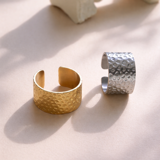 Gold and silver textured cuffs on a light surface