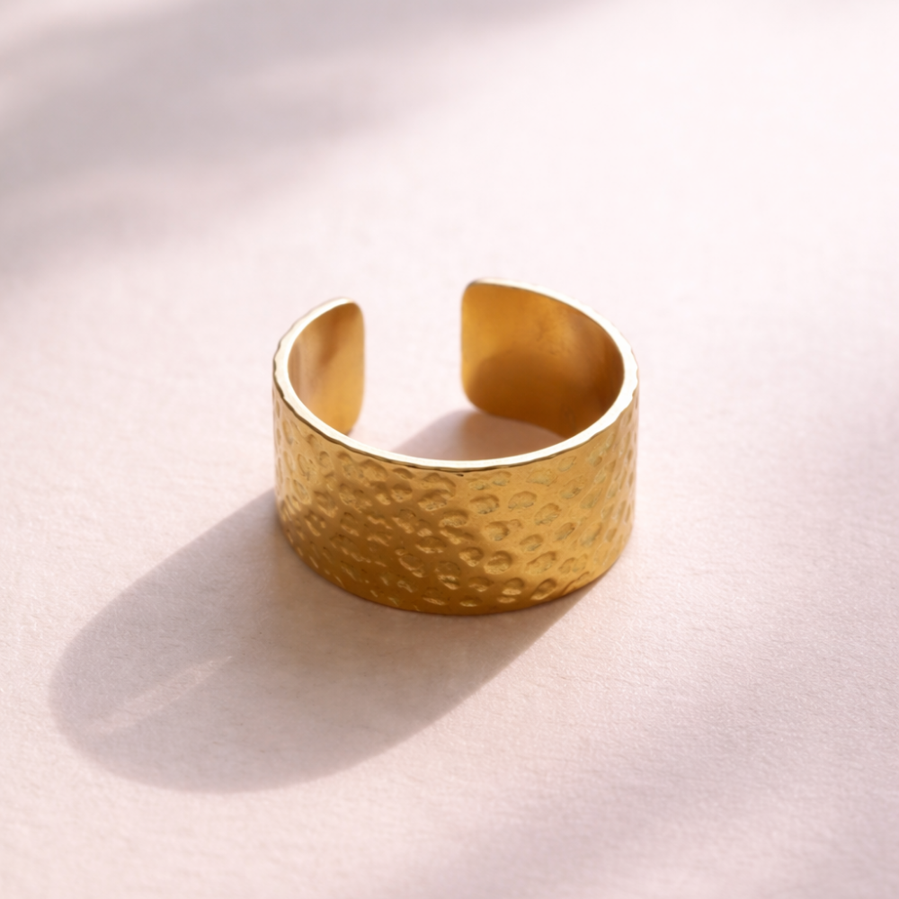 Gold bracelet on a light pink background