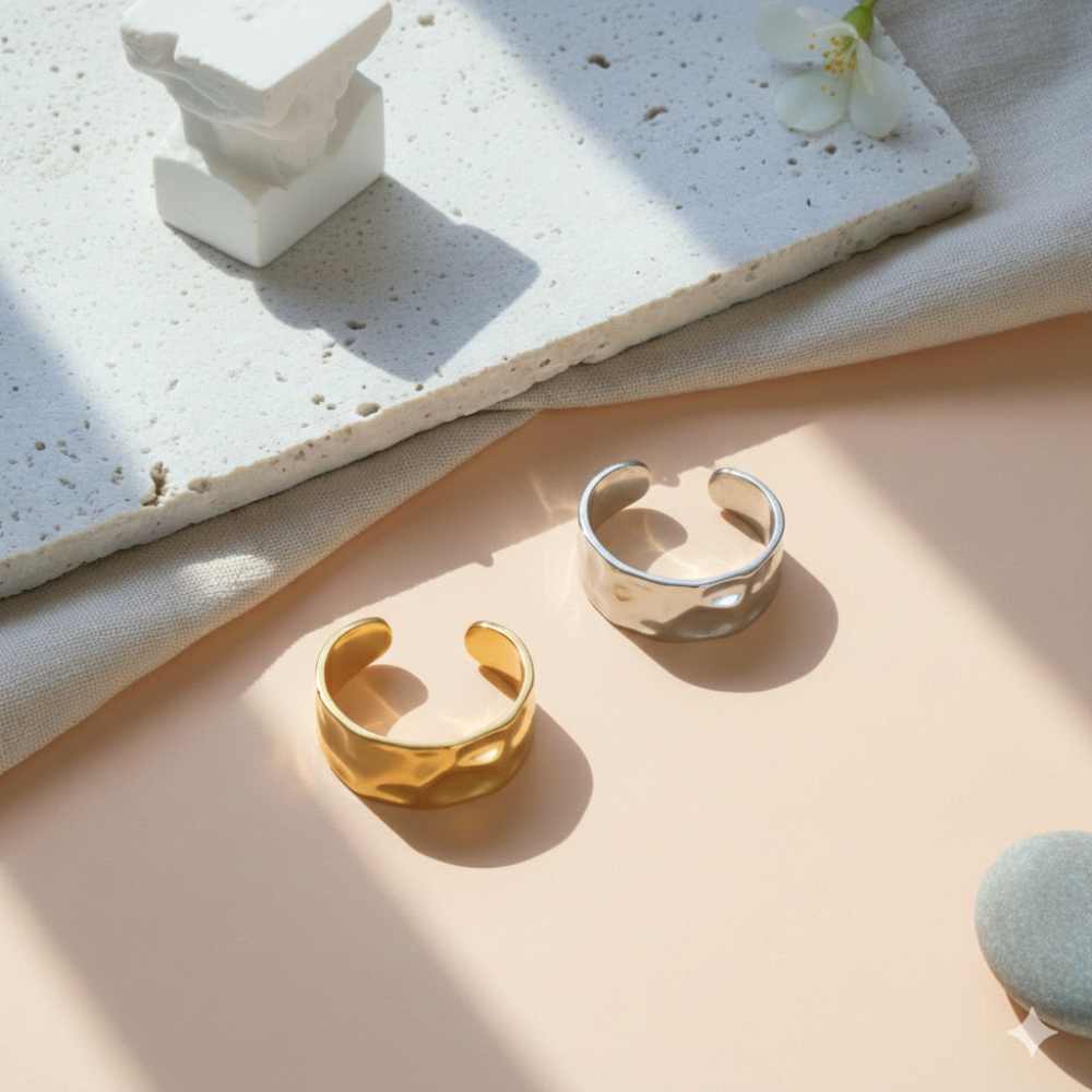 Gold and silver rings on a textured surface with a light background