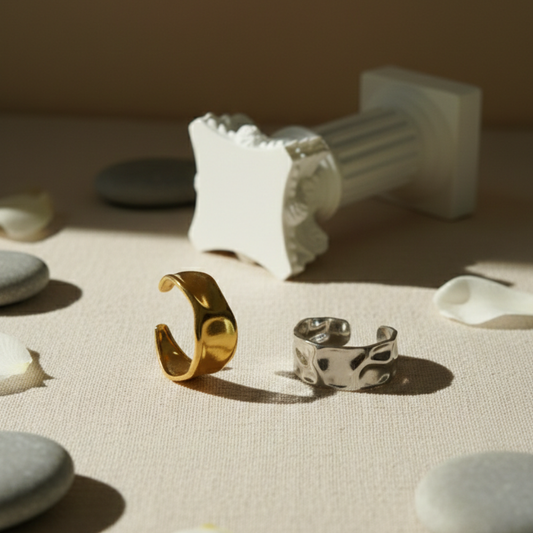 Gold and silver rings on a textured surface with a neutral background