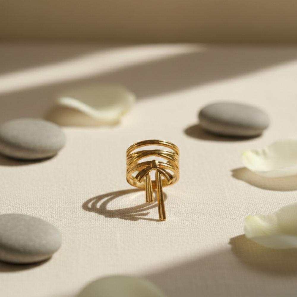 Gold ring with a unique design on a surface with light and shadow effects